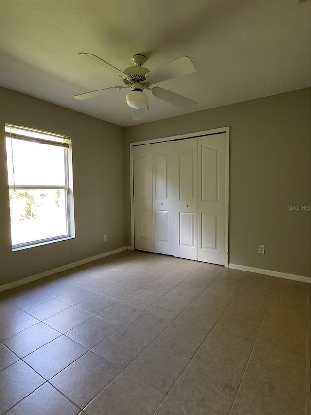 unfurnished bedroom featuring ceiling fan, light tile patterned floors, and a closet