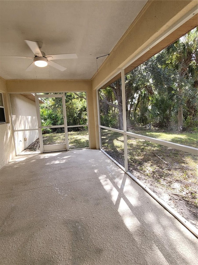 unfurnished sunroom featuring ceiling fan