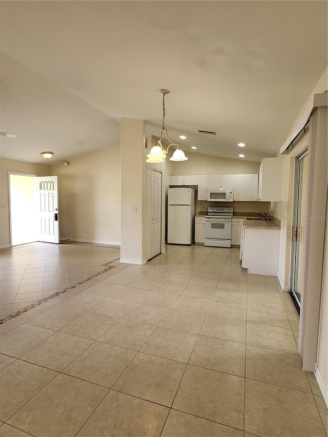 kitchen featuring white appliances, vaulted ceiling, a notable chandelier, white cabinetry, and hanging light fixtures