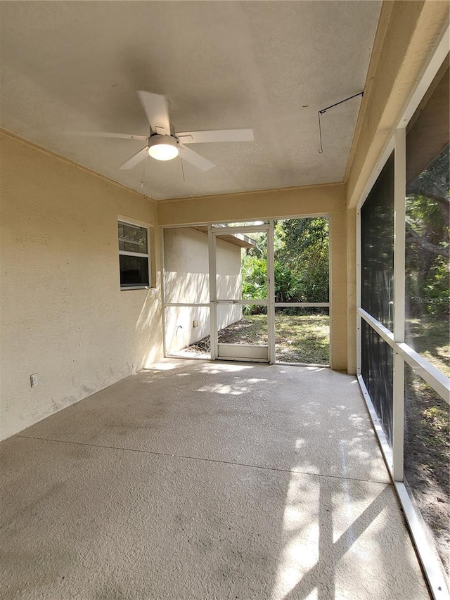 unfurnished sunroom with ceiling fan