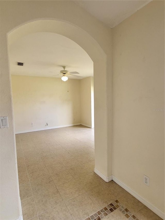 spare room with ceiling fan and light tile patterned flooring