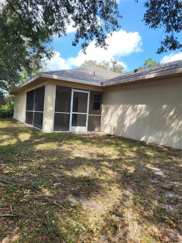 rear view of property with a sunroom and a lawn