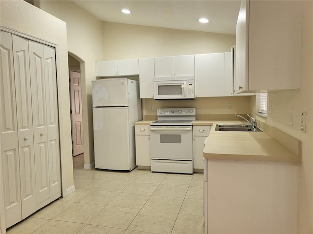 kitchen featuring white cabinets, white appliances, lofted ceiling, and sink