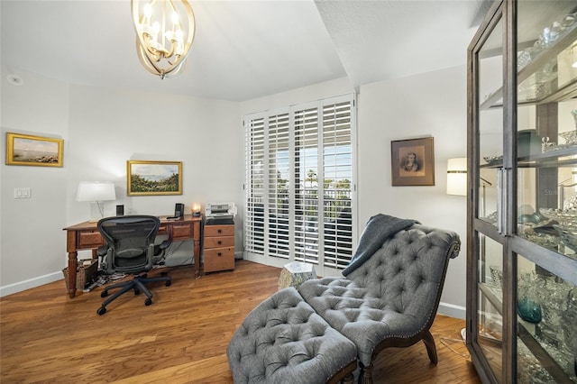 office with hardwood / wood-style floors and an inviting chandelier