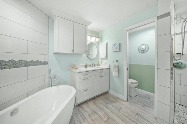 bathroom with vanity, a tub to relax in, and toilet