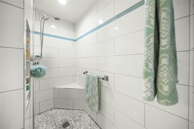 bathroom featuring tile walls and tiled shower