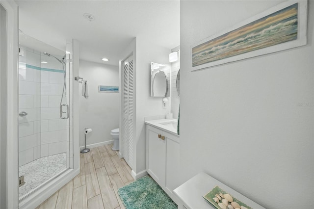 bathroom with vanity, toilet, and a shower with shower door