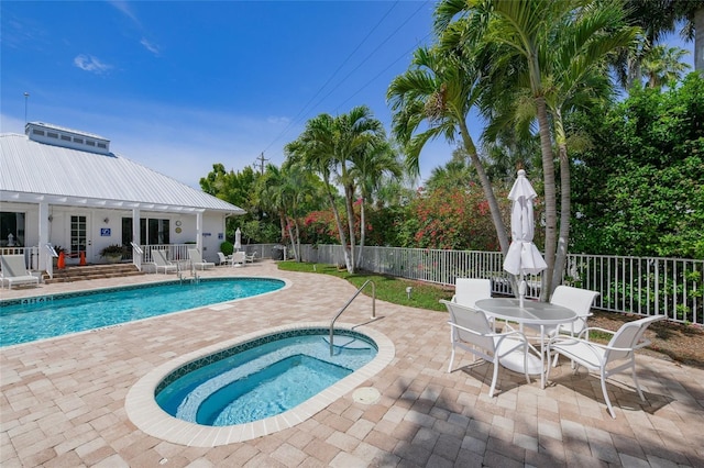 view of swimming pool featuring an in ground hot tub and a patio