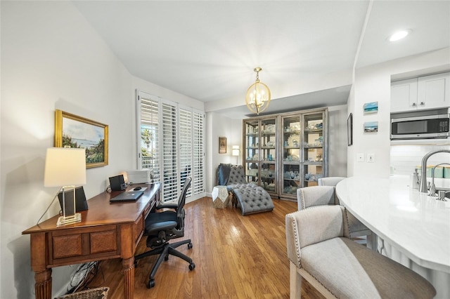 office with sink, a chandelier, and light hardwood / wood-style floors