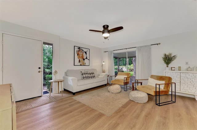 living room featuring light hardwood / wood-style flooring and ceiling fan