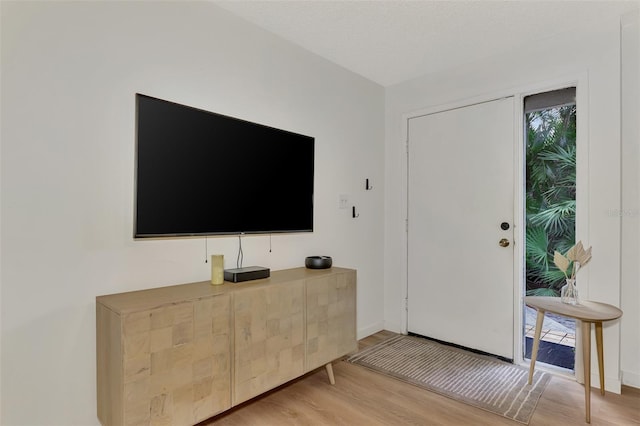 entrance foyer with light wood-type flooring and a textured ceiling