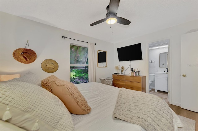 bedroom featuring ensuite bath, ceiling fan, and light hardwood / wood-style flooring