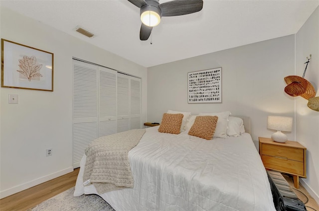 bedroom featuring hardwood / wood-style flooring, ceiling fan, and a closet