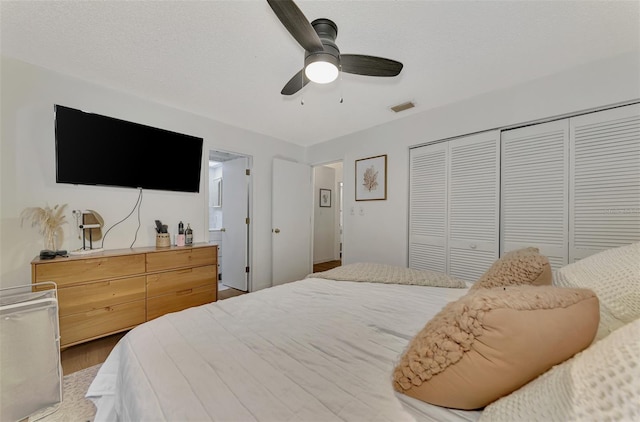 bedroom featuring a closet, ceiling fan, and a textured ceiling