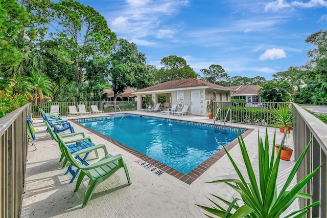 view of swimming pool with a patio and an outbuilding