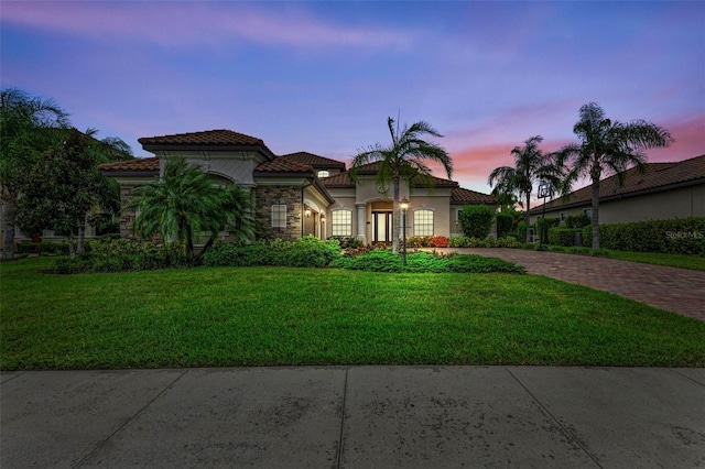 mediterranean / spanish house featuring a lawn