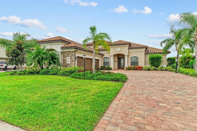 mediterranean / spanish home with a garage and a front lawn