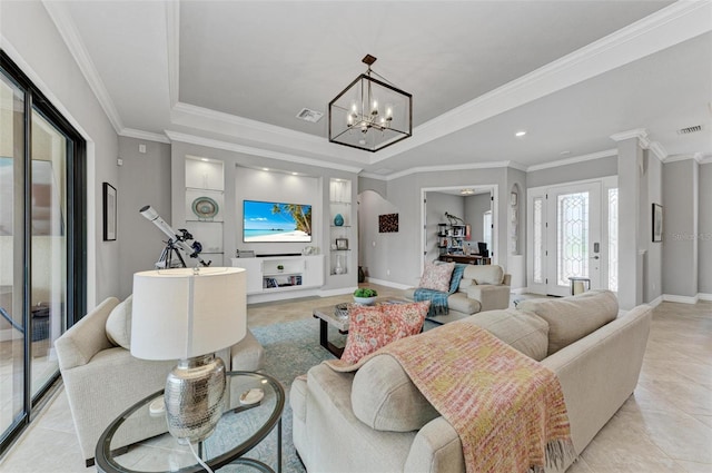 tiled living room with built in shelves, a notable chandelier, and crown molding