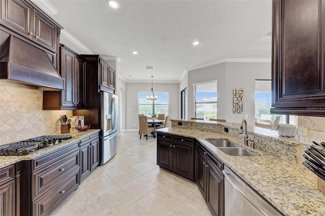 kitchen with tasteful backsplash, sink, stainless steel appliances, and decorative light fixtures