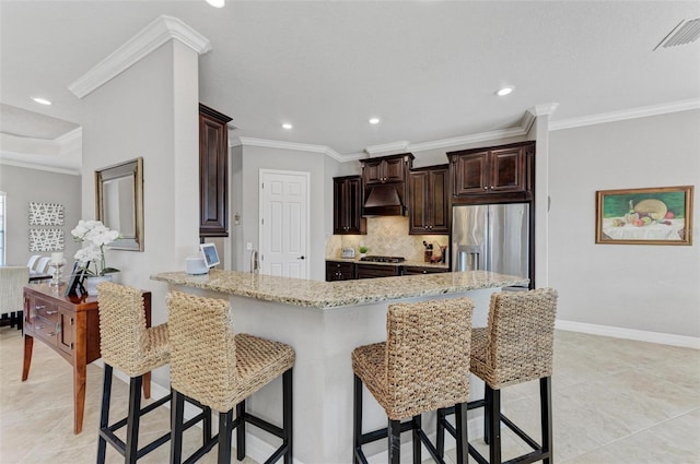 kitchen with appliances with stainless steel finishes, kitchen peninsula, a breakfast bar area, light stone countertops, and crown molding