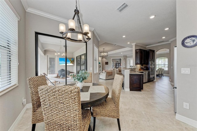 tiled dining area featuring crown molding and an inviting chandelier