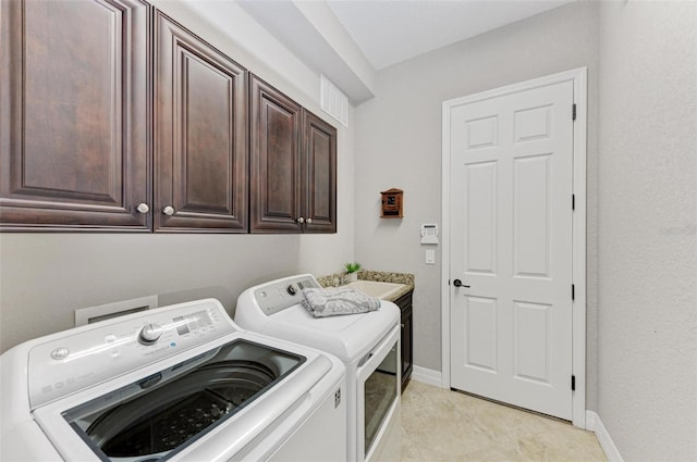 laundry area featuring washer and clothes dryer, cabinets, and sink