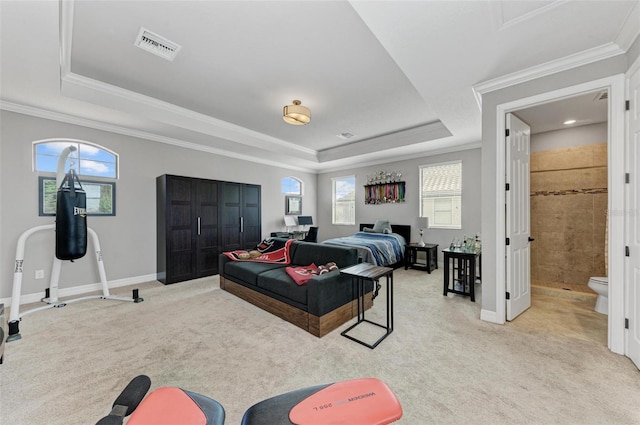 bedroom with a raised ceiling, connected bathroom, crown molding, and light carpet