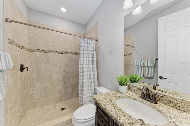 bathroom featuring curtained shower, vanity, and toilet