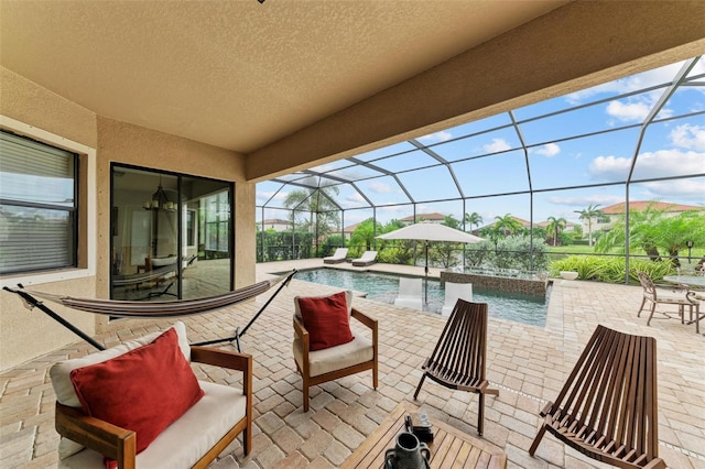 view of swimming pool featuring glass enclosure and a patio