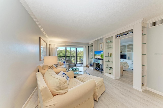 living room with a textured ceiling, ornamental molding, light hardwood / wood-style flooring, and built in features