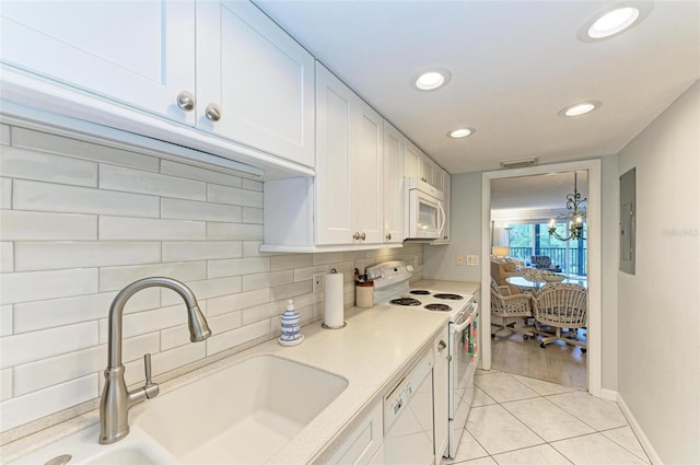 kitchen with decorative backsplash, white cabinetry, sink, and white appliances