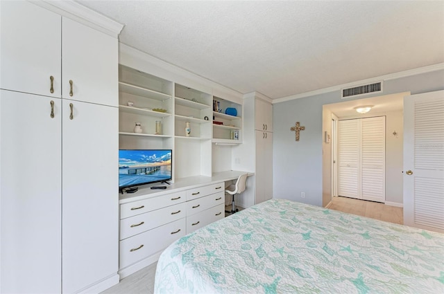 bedroom featuring crown molding, a textured ceiling, and light wood-type flooring