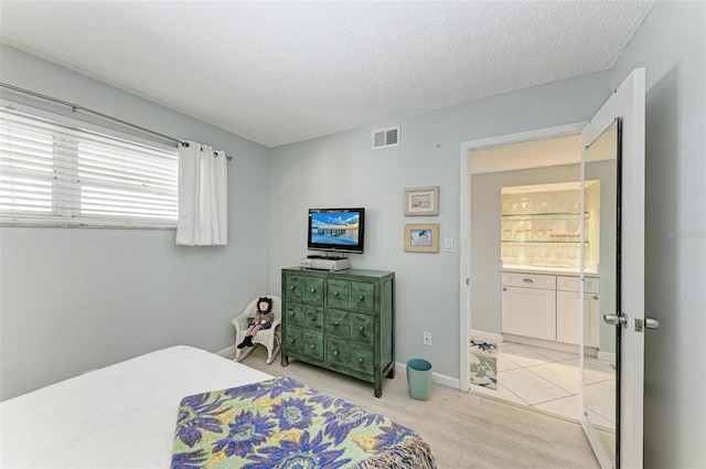 bedroom featuring a textured ceiling and light hardwood / wood-style floors