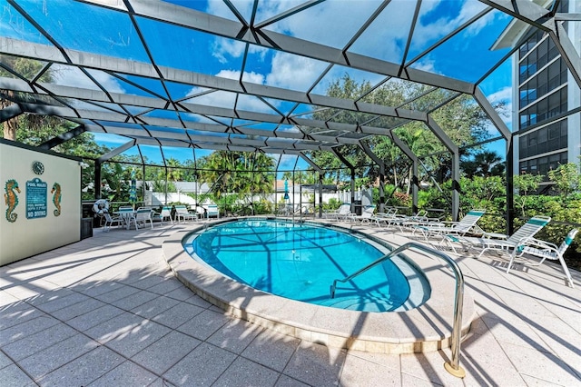 view of swimming pool with a patio area and a lanai