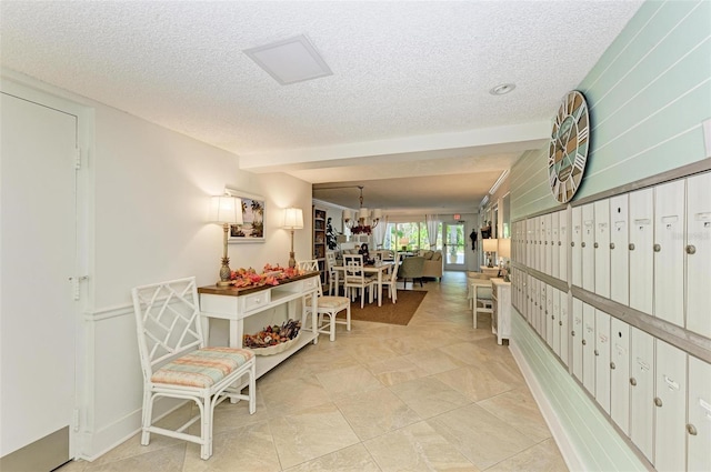 hall featuring a mail area, a textured ceiling, and light tile patterned floors