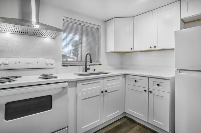 kitchen featuring white cabinetry, white appliances, dark hardwood / wood-style flooring, sink, and wall chimney range hood