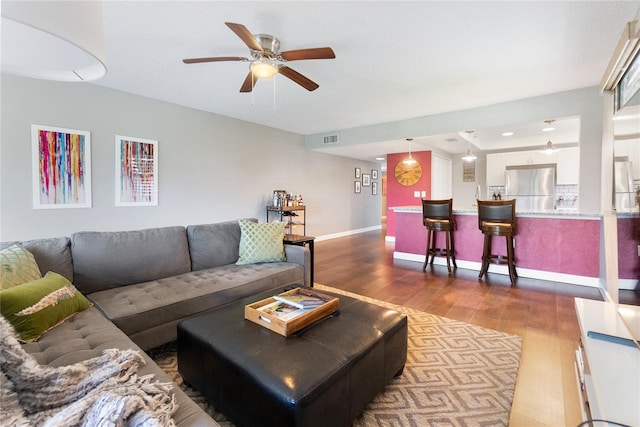 living room with ceiling fan and dark hardwood / wood-style floors