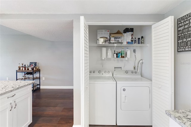 washroom featuring a textured ceiling, washing machine and dryer, and dark hardwood / wood-style floors