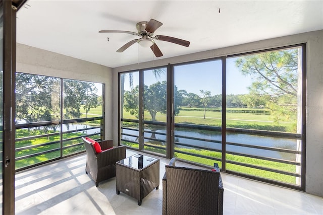 sunroom / solarium featuring ceiling fan and a water view