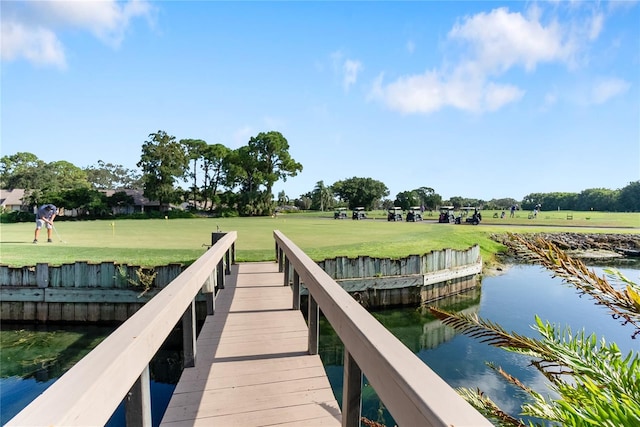 view of dock with a yard and a water view