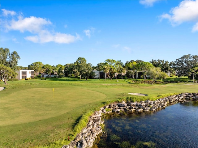 view of property's community featuring a lawn and a water view