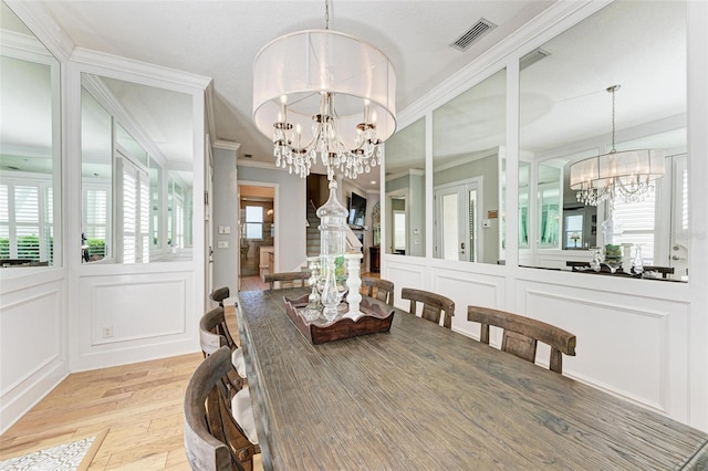 dining space featuring light hardwood / wood-style flooring, a chandelier, and crown molding