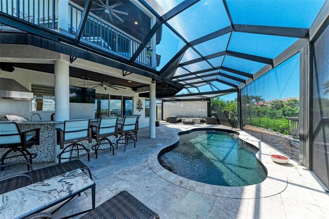 view of pool with glass enclosure, a patio, a jacuzzi, ceiling fan, and an outdoor bar