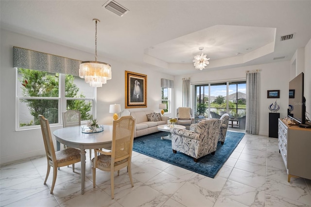 living room with a tray ceiling and a chandelier