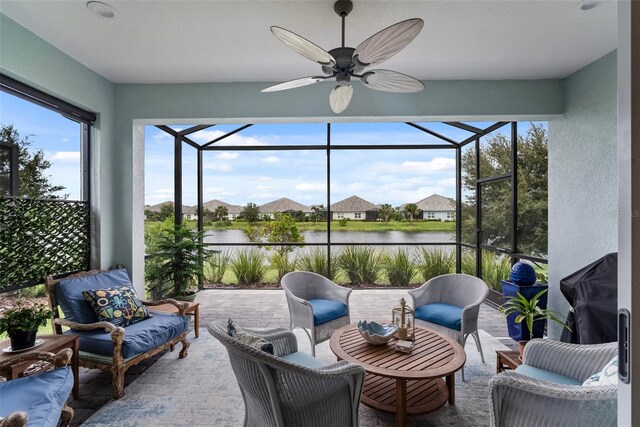 sunroom featuring a water view and ceiling fan