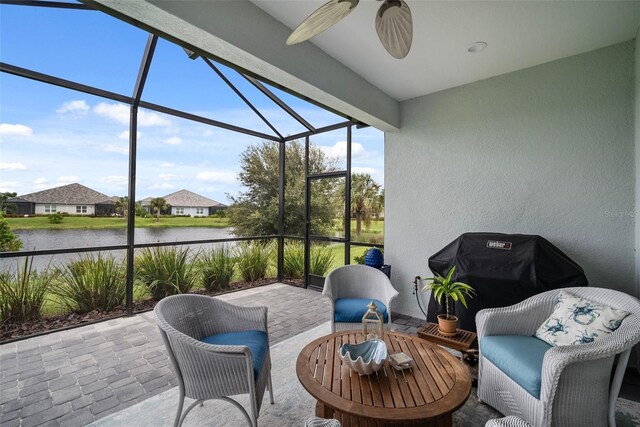 sunroom / solarium with a water view and ceiling fan