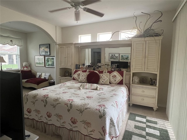 bedroom with ceiling fan, light tile patterned floors, and multiple windows