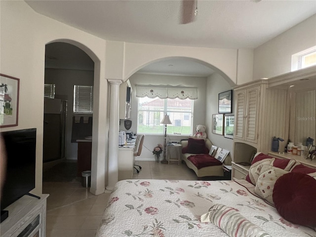 tiled bedroom featuring decorative columns and multiple windows