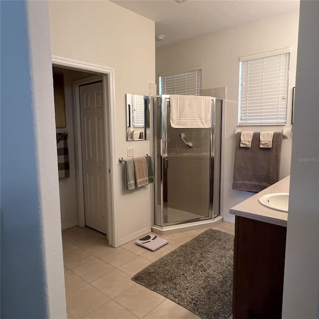 bathroom featuring vanity, tile patterned flooring, and a shower with door