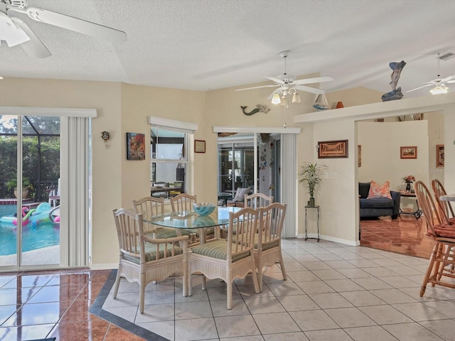 dining room with lofted ceiling, light tile patterned floors, and a textured ceiling